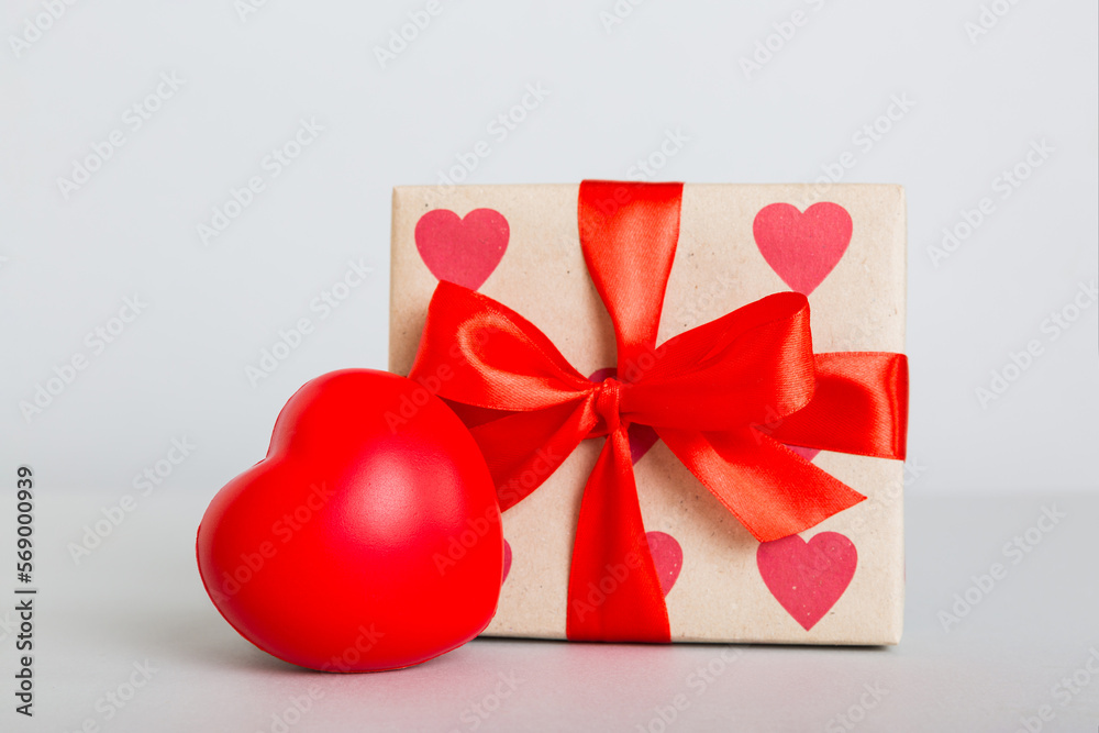 gift box with red bow and red heart on colored background. Perspective view. Flat lay gift box with red bow and red heart on colored background. Perspective view. Flat lay
