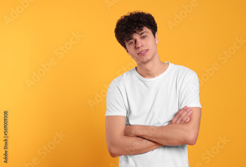 Portrait of handsome young man on orange background. Space for text
