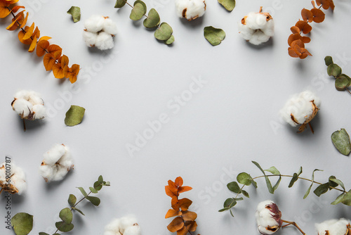 Fluffy cotton flowers and leaves on light grey background, flat lay. Space for text