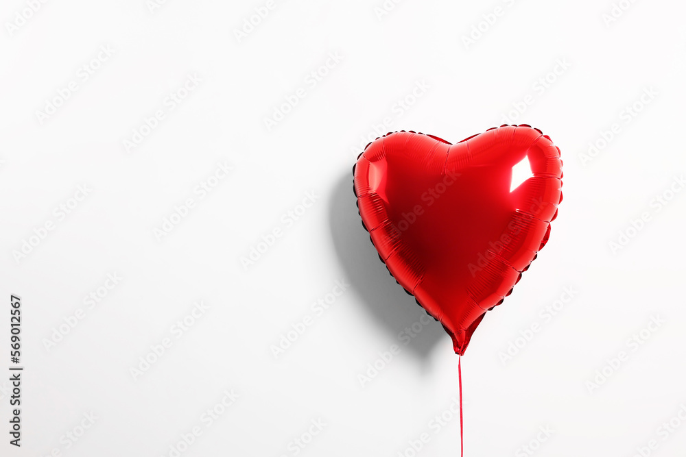 Red heart shaped balloon on white background, space for text
