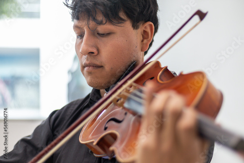 close up of a hand of a hispanic viola player, focus on hand. latin hispanic violin player playing viola or violin photo