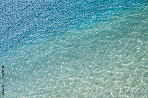 Background of marine water surface, sun's rays shimmer on water surface, diagonal lines, top view