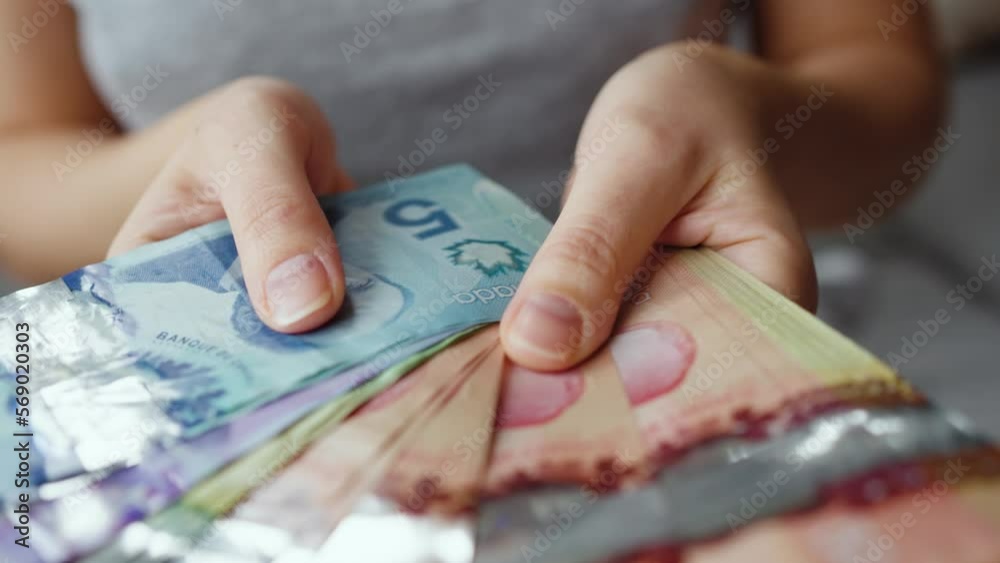 Female hands counting Canadian Dollar bills, close-up. Female hands counting Canadian Dollar bills, close-up.