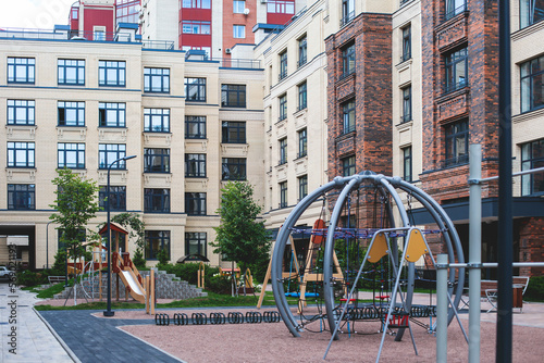 Modern european residential apartment complex yard territory, multi-story house buildings with playground and benches, contemporary scandinavian housing development, facade exterior and courtyard