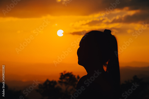 Canvas Print silhouette young woman is looking at the sunset.
