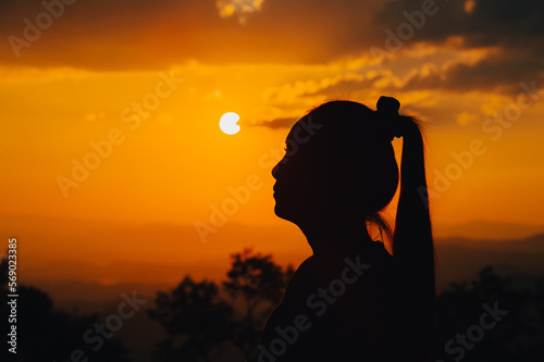 silhouette young woman is looking at the sunset.