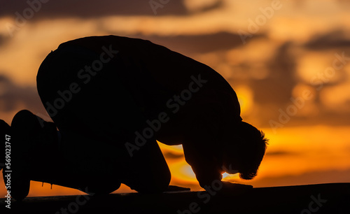 A Muslim prayer man praying at sunset. photo