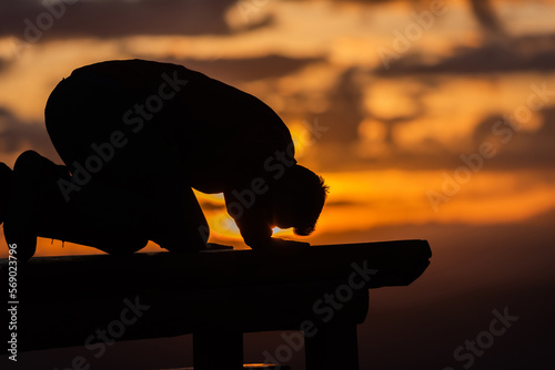 A Muslim prayer man praying at sunset. photo