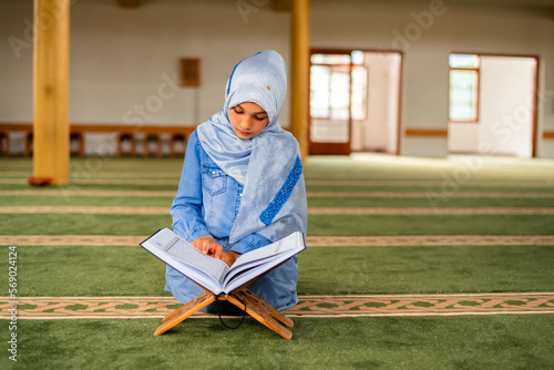Billede på lærred A Muslim girl reading a holy book Quran inside the mosque.