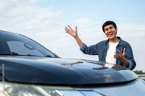 Young handsome asian man getting the new car. He hugged his car and was very happy touching detail interior . Buy or rent car concept. © Chanakon