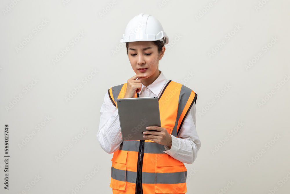 Asian engineer worker woman or architect with white safety helmet standing on isolated white background. Mechanic service factory Professional job occupation in uniform working with tablet Asian engineer worker woman or architect with white safety helmet standing on isolated white background. Mechanic service factory Professional job occupation in uniform working with tablet