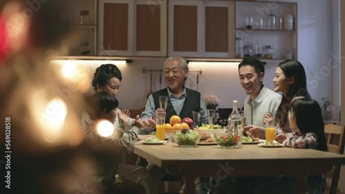 three generation happy asian family having dinner at home on christmas eve
