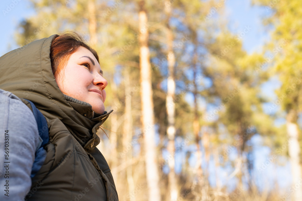 Side view photo of calm woman warm dressed in the forest enjoying the nature for feeling free and spend wonderful day. Side view photo of calm woman warm dressed in the forest enjoying the nature for feeling free and spend wonderful day.