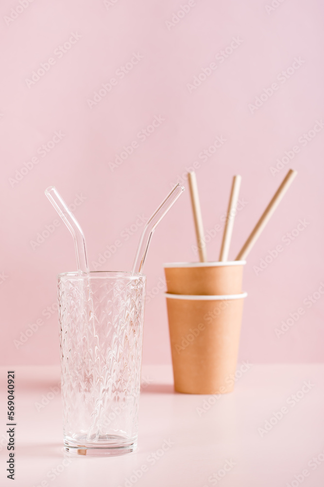 Reusable glass cup and straw vs paper cups and straws. Zero waste. Vertical view. Reusable glass cup and straw vs paper cups and straws. Zero waste. Vertical view.