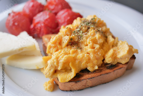 morning breakfast with Scrambled eggs on a bread on white plate 