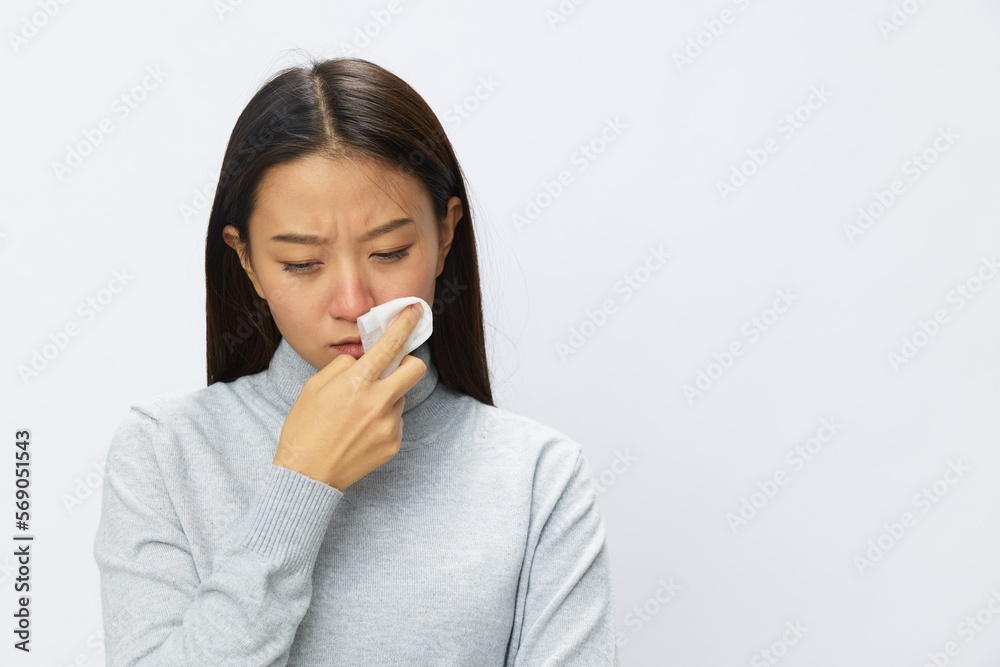 Sad Asian woman holding hand with handkerchief and coughing up flu and cold, stuffy nose viral disease asthma and allergies covid 19, white background Sad Asian woman holding hand with handkerchief and coughing up flu and cold, stuffy nose viral disease asthma and allergies covid 19, white background