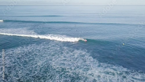 Surfers riding hard waves at waikiki beach in honolulu hawaii on a clear sky day, AERIAL DOLLY photo