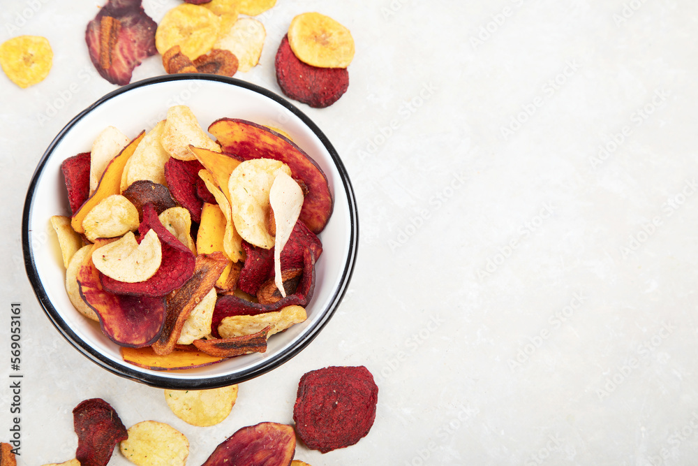 Vegetable organic chips made from potatoes, beets and carrots in a white plate for a snack, top view. Vegetable organic chips made from potatoes, beets and carrots in a white plate for a snack, top view.