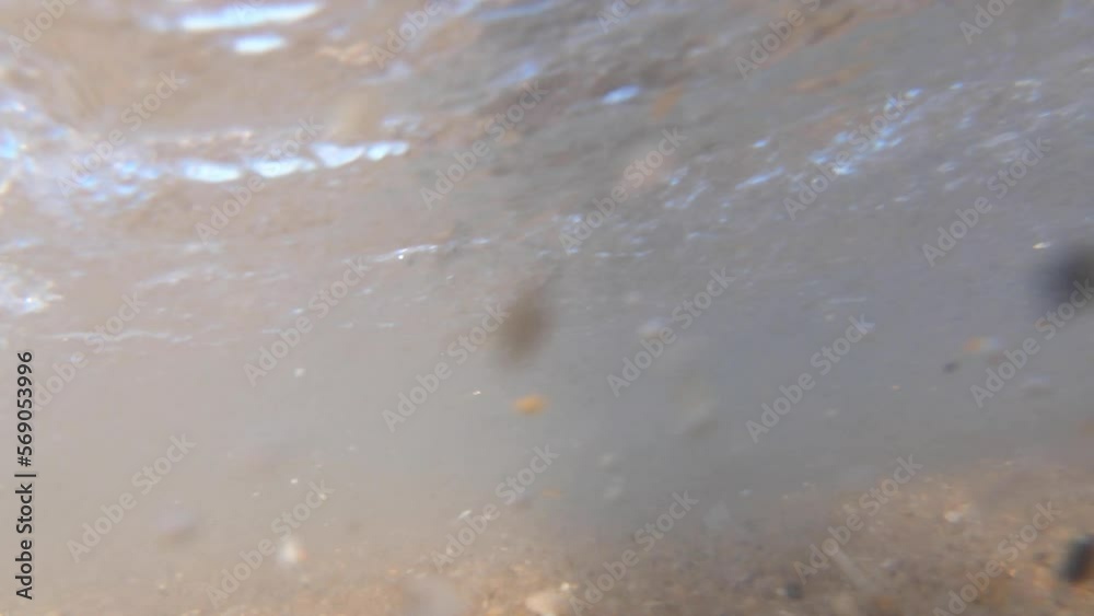 A ground level shot of the waves crashing on the shore. We can see in the shot waves breaking on the camera and we can also see the underwater aftermath as the waves pass by A ground level shot of the waves crashing on the shore. We can see in the shot waves breaking on the camera and we can also see the underwater aftermath as the waves pass by