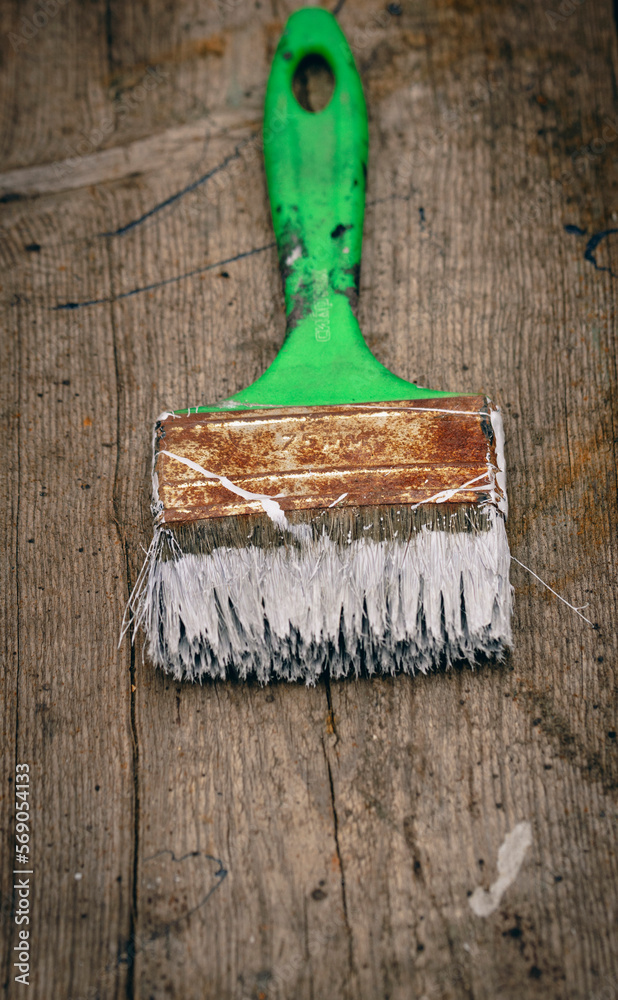Brush covered with paint on a wooden background Brush covered with paint on a wooden background