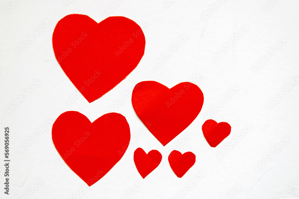 Red and pink paper hearts of different sizes on a light background, celebration of love, Valentine's day concept