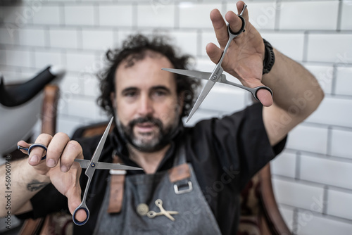 Portrait of a barber using scissors in a barber shop