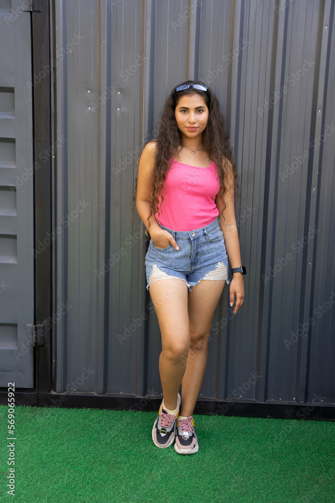 Young attractive fashionable indian woman wearing casual jeans short outfit  standing outdoor. Copy space. Stock Photo | Adobe Stock