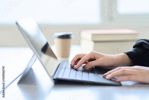 ノートパソコンでネットサーフィンをするアジア人女性