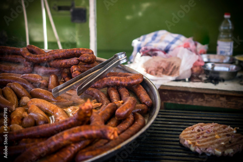 An outdoor food stall selling grilled homemade sausages