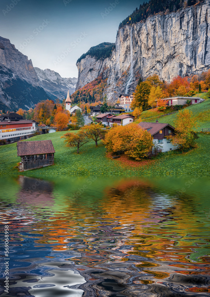 Lauterbrunnen village reflected in the calm waters of small lake. Impressive rural scene of Swiss Alps, Bernese Oberland in the canton of Bern, Switzerland. Beauty of countryside concept background..