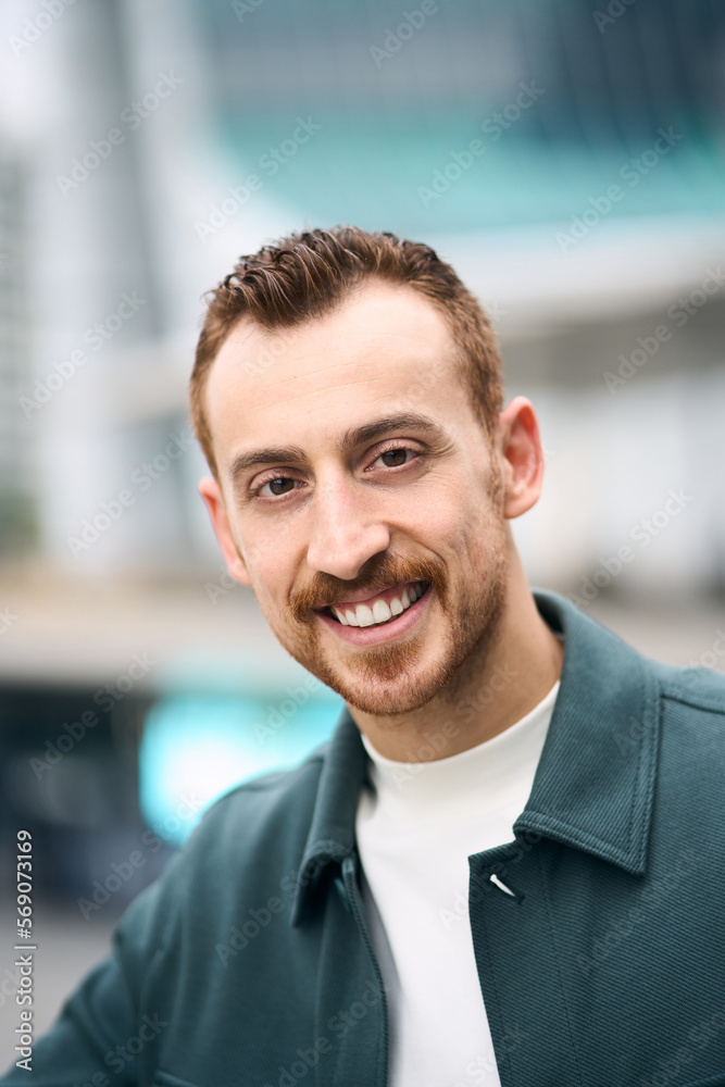 Vertical portrait of happy red haired confident man smiling and looking at camera Vertical portrait of happy red haired confident man smiling and looking at camera