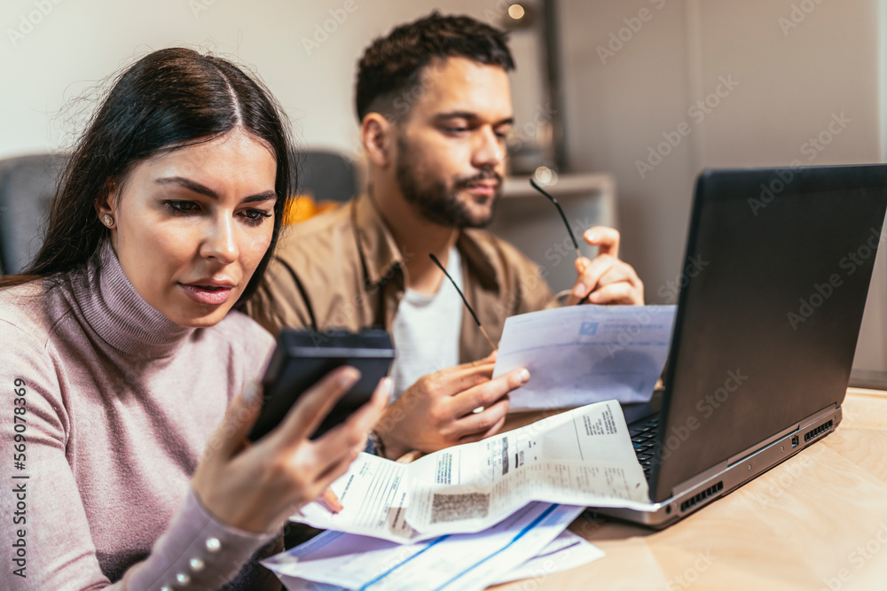 Portrait of young couple calculating budget at home. Portrait of young couple calculating budget at home.