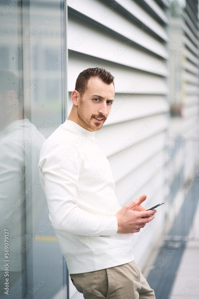 Young handsome man holding smartphone using mobile app shopping online Young handsome man holding smartphone using mobile app shopping online