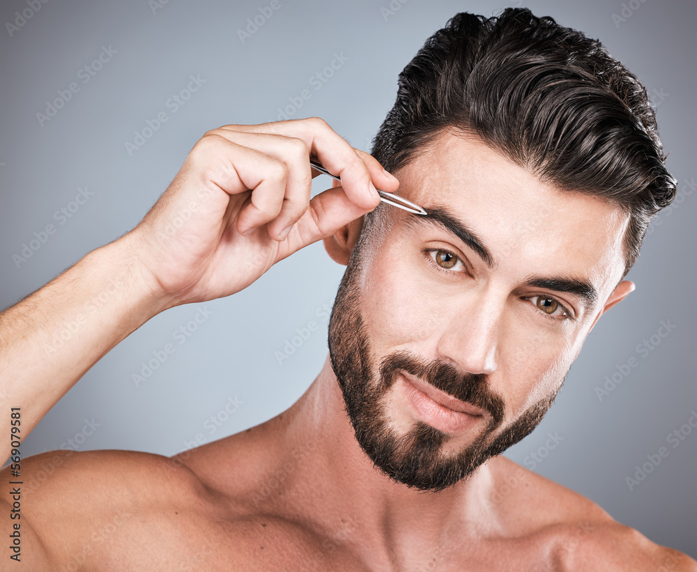 Obraz premium Face, eyebrow and man with tweezers in studio isolated on a gray background for wellness. Health, hair removal and portrait of male model with facial product for grooming, cleaning and epilation.