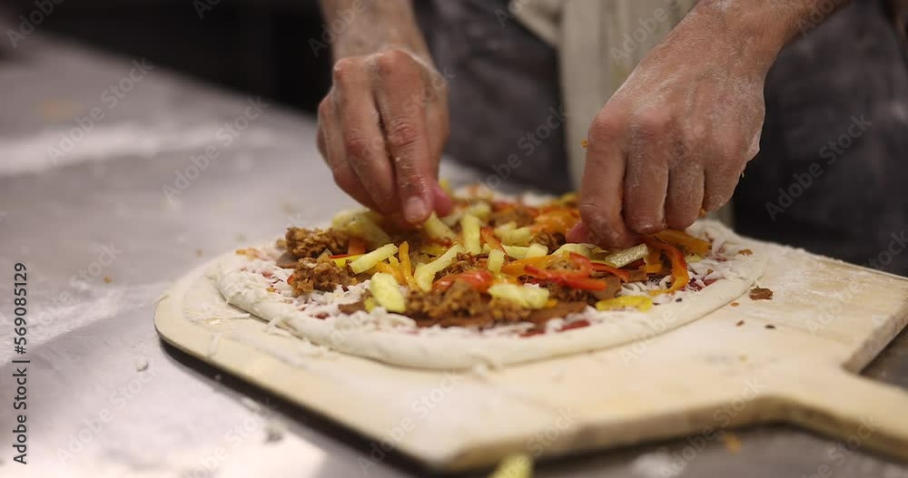 Close up of the making process, male hands preparing, stretching, and placing ingredients in uncooked raw pizza. Close up of the making process, male hands preparing, stretching, and placing ingredients in uncooked raw pizza.