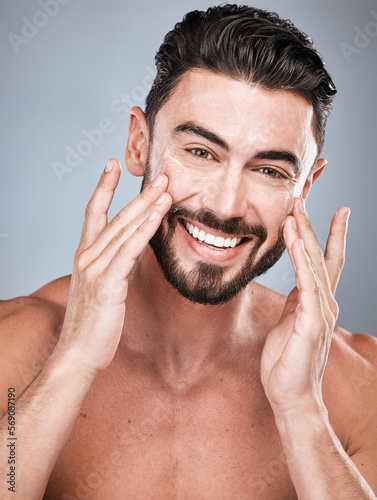 Portrait, skincare and man with cream in studio isolated on a gray background for facial wellness. Face, dermatology cosmetics or happy male model with lotion, creme or moisturizer product for health
