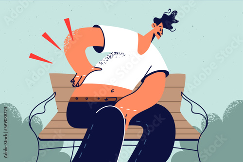 Unhealthy man on park bench suffer from backache 