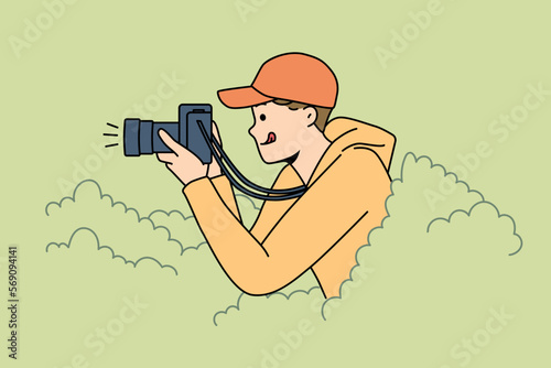 Smiling young man hide in bushes make pictures with professional camera. Happy guy journalist or reporter take photos from hidden spot. Vector illustration. 