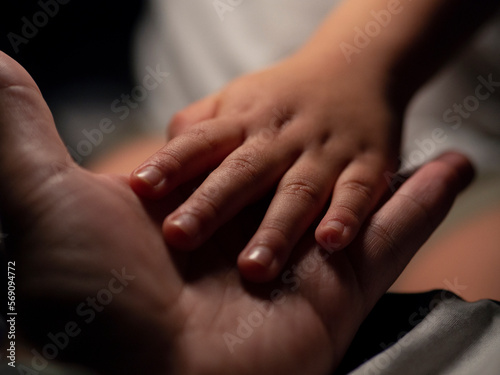 A child's hand on his father's hand. photo