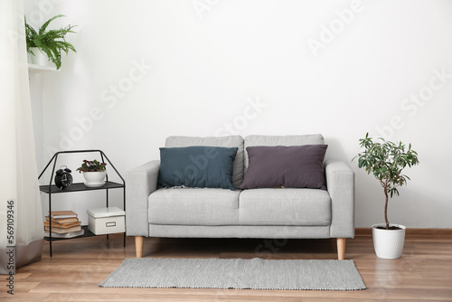 Grey sofa with cushions in interior of light living room