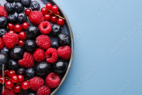 Plate of fresh berries on color background  closeup