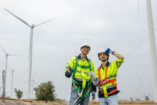 Team engineer wearing safety uniform discussed plan about renewable energy at station energy power wind. technology protect environment reduce global warming problems.