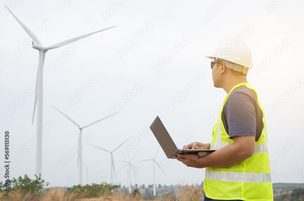 Engineer checking wind turbine operation on a laptop computer Engineer checking wind turbine operation on a laptop computer