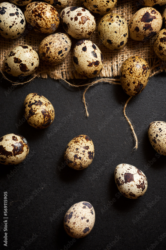 Obraz premium Quail eggs on a black table.