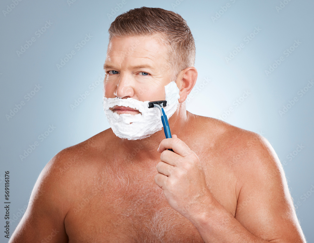Portrait, shaving cream and man with razor in studio isolated on a blue background for hair removal. Face, skincare and mature male model with facial foam to shave for aesthetics, health or wellness