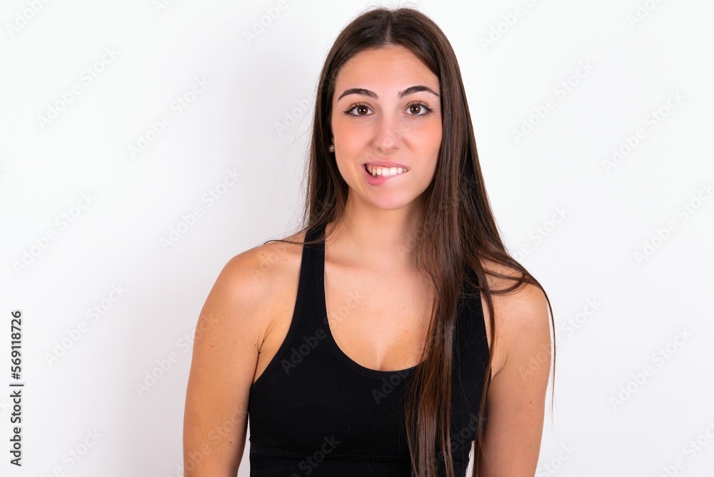 young woman wearing sportswear over white studio background being nervous and scared biting lips looking camera with impatient expression, pensive. young woman wearing sportswear over white studio background being nervous and scared biting lips looking camera with impatient expression, pensive.
