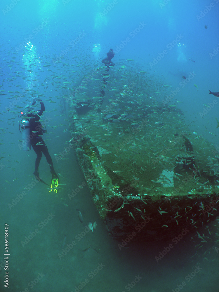 some divers in a small sunken ship in the crystal clear waters of the caribbean sea some divers in a small sunken ship in the crystal clear waters of the caribbean sea