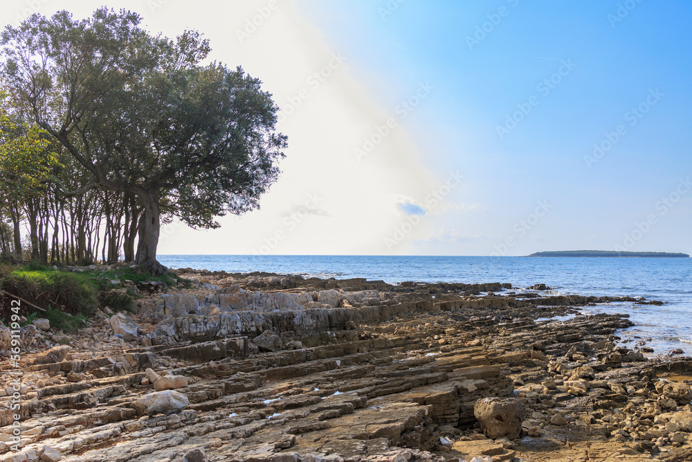 Rocky beach with blue sea at Cisterna Beach near Rovinj Rocky beach with blue sea at Cisterna Beach near Rovinj