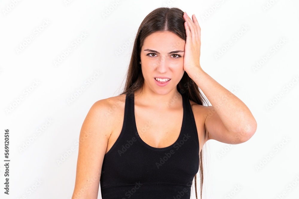 Portrait of confused young woman wearing sportswear over white studio background holding hand on hair and frowning, panicking, losing memory. Worried and anxious can not remember anything. Portrait of confused young woman wearing sportswear over white studio background holding hand on hair and frowning, panicking, losing memory. Worried and anxious can not remember anything.