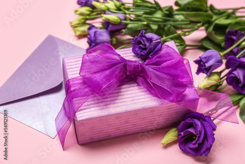 Fototapeta Naklejka Na Ścianę i Meble -  Beautiful eustoma flowers, envelope and gift for Women's Day celebration on pink background